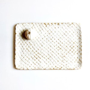 May include: White ceramic rectangular serving tray with a textured, woven pattern. The tray has a slightly raised edge.