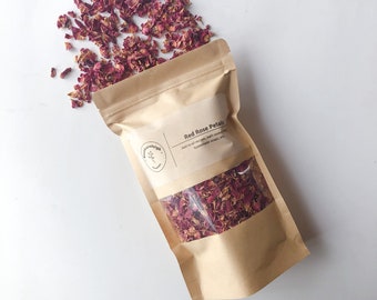 May include: A brown paper bag filled with dried red rose petals. The bag has a label that says "Red Rose Petals" and "Add to all recipes, bath soaks, homemade soaps, etc."