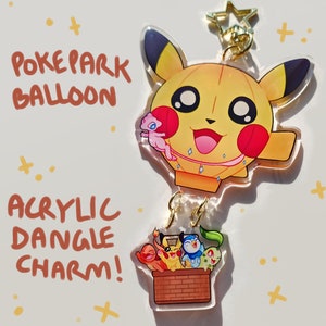 May include: A clear acrylic dangle charm featuring a yellow Pikachu balloon with a pink Mew passenger. Below, a brick basket holds four more Pokemon characters. The text "POKEPARK BALLOON" and "ACRYLIC DANGLE CHARM!" are written on the image.