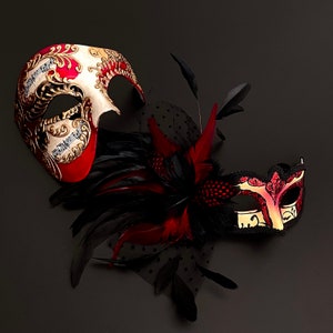 May include: Two masquerade masks with intricate designs. One mask is red and gold with a feathered design. The other mask is red and black with a gold trim. The masks are set against a black background.