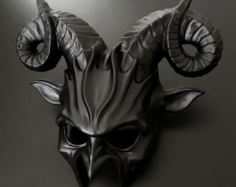 May include: A black masquerade mask with horns, resembling a demon or satyr. The mask has a detailed, textured design and eye holes.