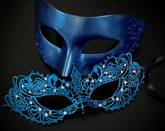 May include: Two elegant masquerade masks. One is a solid, glossy blue with subtle glitter accents. The other is a delicate, openwork design in a vibrant blue, adorned with sparkling rhinestones. Both masks are set against a black background.