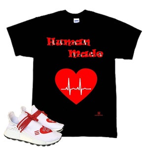 May include: A black t-shirt with the words "Human Made" in red lettering and a red heart with a white EKG line. A pair of white sneakers with red laces and a red heart graphic on the side.