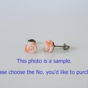 Puede incluir: Un par de pendientes de botón con forma de rosa. Los pendientes son de color coral claro y tienen un diseño floral detallado. Los postes y los respaldos son de metal plateado. El texto de la imagen dice: "Esta foto es una muestra. Por favor, elija el número que desea comprar."