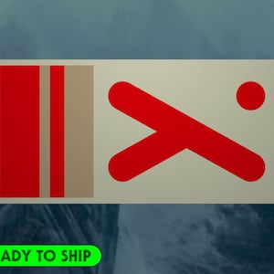 Peut inclure: Un autocollant rectangulaire avec un fond crème. Le côté gauche présente deux rayures rouges verticales et une rayure beige. Le côté droit comporte un motif rouge incliné et un point rouge. Le texte "READY TO SHIP" est en vert en bas à gauche.