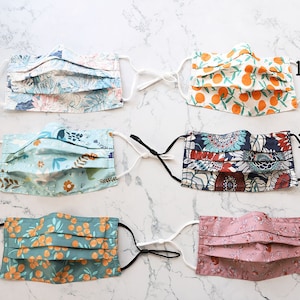 May include: Six different fabric face masks with various patterns, including floral, geometric, and citrus prints. The masks are labeled with numbers 118A through 118F.