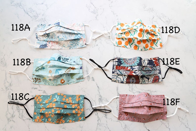 May include: Six different fabric face masks with various patterns, including floral, geometric, and citrus prints. The masks are labeled with numbers 118A through 118F.
