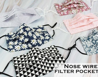 May include: Five different fabric face masks with nose wire and filter pocket. The masks are in various patterns, including floral, geometric, and polka dots.