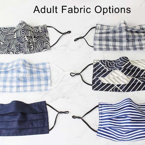 May include: Six different fabric options for face masks. The fabrics include a blue and white gingham, a navy blue solid, a blue and white stripe, a black and white geometric pattern, and two different blue and white wave patterns.