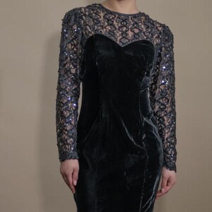 May include: A black velvet dress with a lace overlay and long sleeves. The lace has a geometric pattern and is embellished with sequins.