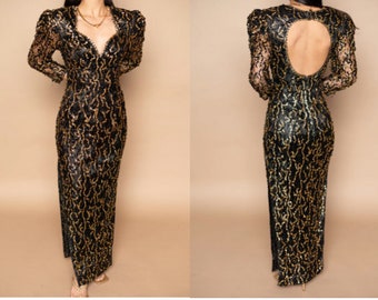 Peut inclure: Une robe longue à sequins noire et dorée à manches longues, avec un décolleté plongeant et un dos ajouré. La robe est cintrée et possède une fente sur le côté.