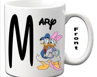 Tazas blancas personalizadas con iniciales y estampado de los personajes Donald y Daisy Duck.