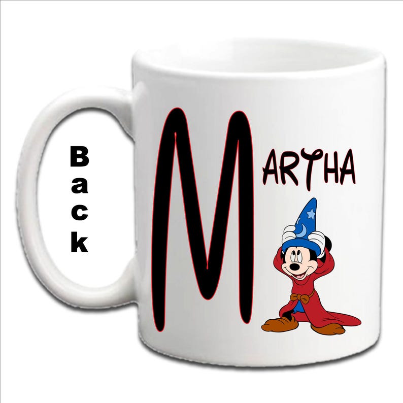May include: White ceramic mug with a black "M" and the name "MARTHA" in black lettering. A cartoon Mickey Mouse wearing a wizard hat and red robe is on the right side of the mug.