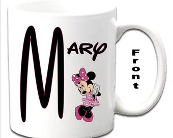 ミニーマウスのキャラクターがプリントされた、イニシャル入りの白いマグカップ
