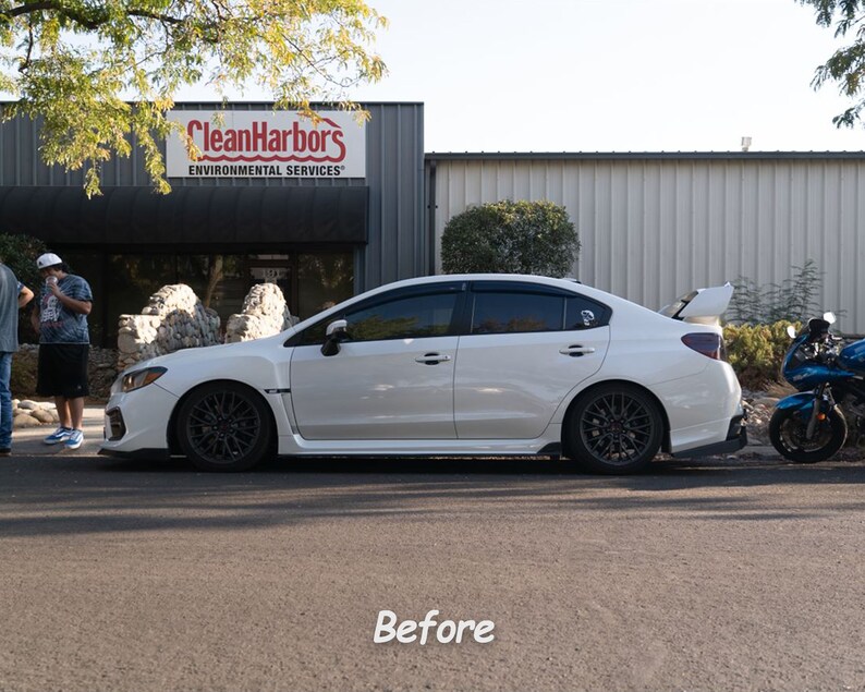 May include: A white Subaru WRX with black wheels and tinted windows parked in front of a building with the sign "CleanHarbors Environmental Services".