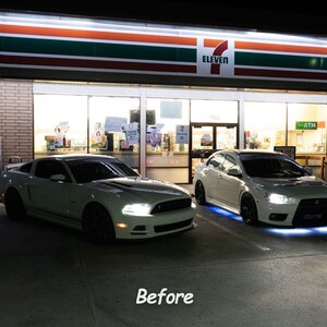 May include: Two white cars parked in front of a 7-Eleven store at night. The car on the left is a Ford Mustang and the car on the right is a Mitsubishi Lancer Evolution. Both cars have aftermarket LED lights.