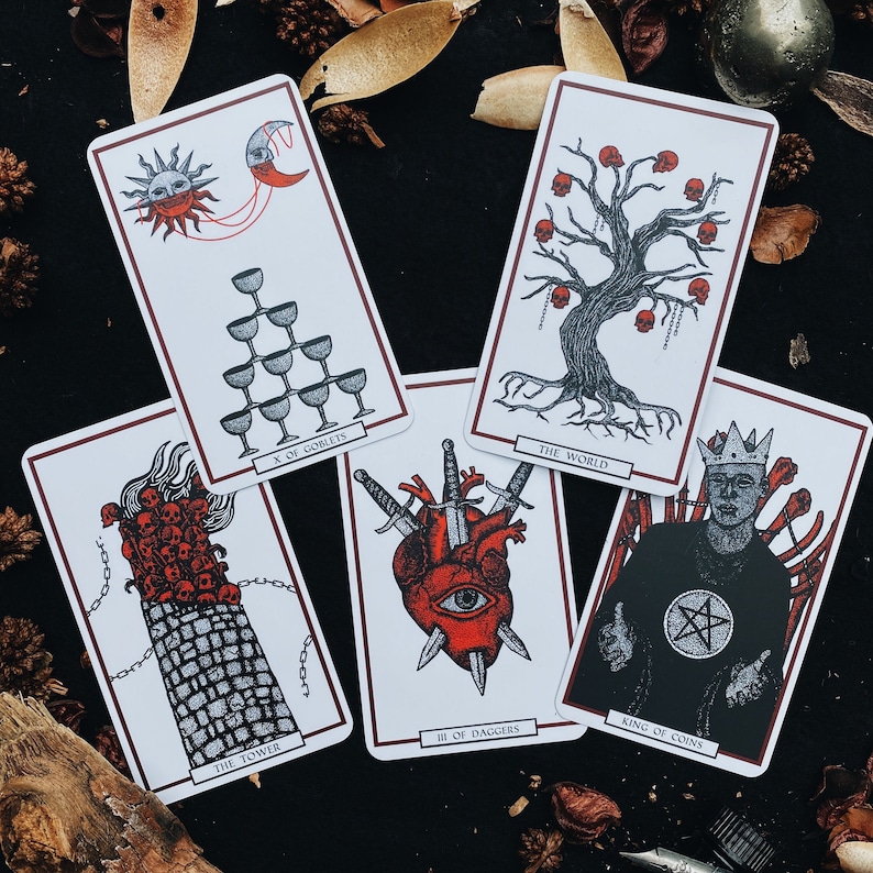 May include: Ten tarot cards with colorful illustrations and text. The cards include "The World", "King of Coins", "III of Daggers", "The Tower", and "X of Goblets".