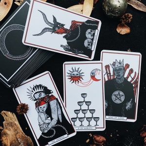 May include: A set of ten tarot cards featuring illustrations of various characters and symbols. The cards are printed on thick cardstock with a matte finish. The cards include The Devil, The Empress, X of Goblets, and King of Coins.
