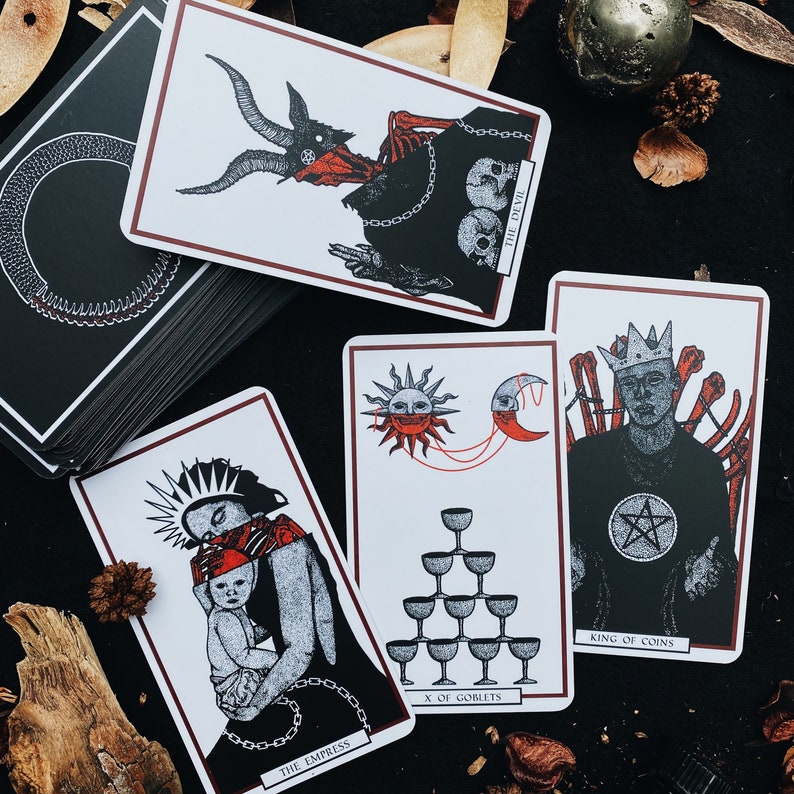 May include: A set of ten tarot cards featuring illustrations of various characters and symbols. The cards are printed on thick cardstock with a matte finish. The cards include The Devil, The Empress, X of Goblets, and King of Coins.
