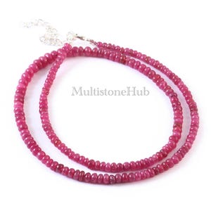 May include: A double strand necklace made of small, round, pink ruby beads. The necklace has a silver clasp.