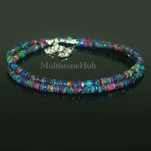 May include: A double strand necklace made of iridescent opal beads. The necklace is silver toned and has a clasp closure.