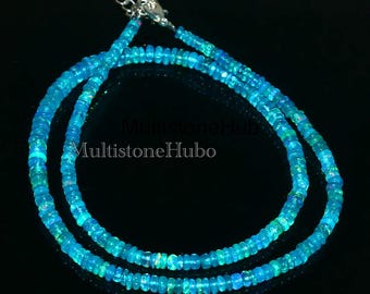 May include: A double strand necklace made of blue opal beads. The necklace is made of small, round beads that are strung together on a silver chain.