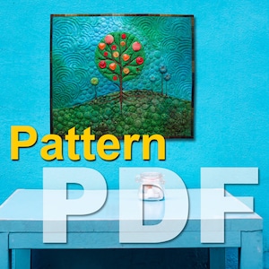 Op de afbeelding: Een gewatteerde wanddecoratie met een boom met rode en oranje vruchten, tegen een groene en blauwe achtergrond. De woorden "Pattern" en "PDF" zijn over elkaar geplaatst. Een klein potje staat op een blauwe tafel.