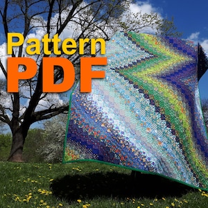 Op de afbeelding: Een kleurrijke quilt met een chevron-ontwerp, met tinten blauw, groen en bloempatronen. De quilt wordt buiten getoond met de tekst "Pattern PDF" in geel en oranje.