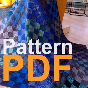 May include: A blue and black patchwork quilt with the text "Pattern PDF" in orange letters.