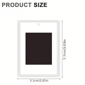 May include: A white picture frame with a black rectangle inside. The frame is 7.7cm tall and 5.1cm wide.