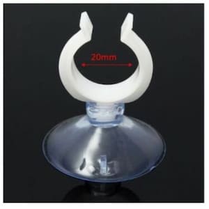 Puede incluir: Soporte de ventosa de plástico blanco con una abertura de 20 mm de diámetro. El soporte está diseñado para sujetarse a una superficie lisa y se puede utilizar para sujetar una variedad de artículos.