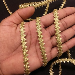 Può includere: Bordatura dorata con un design a festoni. La bordatura è realizzata con un filo metallico e ha una finitura lucida.