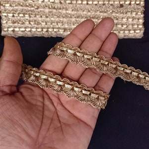 May include: Gold trim with a scalloped edge and fringe detail. The trim is approximately 1 inch wide.