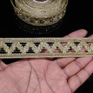Puede incluir: Borde de brillo dorado con un patrón geométrico. El borde tiene un diseño de malla con un patrón repetitivo de pequeños triángulos.
