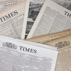 Puede incluir: Una colecci&oacute;n de peri&oacute;dicos antiguos con el t&iacute;tulo "The Times" impreso en cada uno. Los peri&oacute;dicos est&aacute;n apilados uno encima del otro y tienen diferentes fechas.