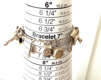 Sterling Silver 7 inch charm bracelet with 17 charms.  REF 3131
