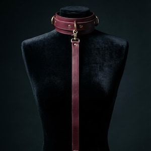 Elegant leather BDSM collar with leash displayed on mannequin, premium handcrafted bondage accessory for couples and intimate play.