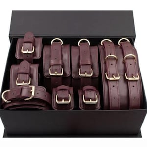 Luxury burgundy leather bondage set in elegant gift box, premium BDSM restraints perfect romantic gift for couples anniversary or wedding.