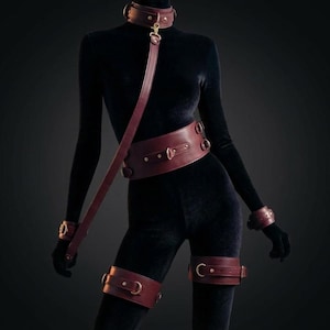 Luxury leather BDSM harness and bondage set worn on female body, burgundy restraint accessories with gold hardware sensual couple gift.