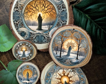 May include: A collection of five circular wood slices featuring intricate, printed illustrations of a cloaked figure standing in a snowy landscape beneath a glowing sun or tree. The designs are framed by ornate, blue-toned, circular patterns.