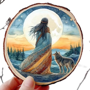 May include: A round wooden slice featuring a watercolor painting of a woman standing before a large moon, with a wolf nearby. The artwork is set against a backdrop of a sunset and starry sky. The text "Wolf 1" is visible.
