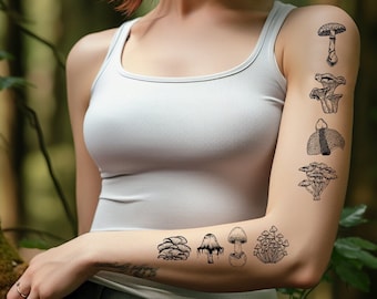 May include: A woman's arm with a series of black and white mushroom tattoos. The tattoos are of different types of mushrooms, including a cluster of mushrooms, a single mushroom with a cap, and a mushroom with a stem and a cap.