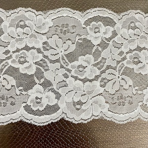 Peut inclure: Bordure en dentelle blanche avec un motif floral. La dentelle a un bord festonné.