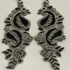 Peut inclure: Deux appliques en dentelle brodée noire et dorée avec des motifs de paisley et floraux. Les appliques sont parfaites pour ajouter une touche d'élégance à tout projet.