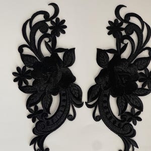 Puede incluir: Dos apliques de tela bordada negra con un diseño floral y una gran rosa en el centro. Los apliques son perfectos para añadir un toque de elegancia a la ropa, los bolsos o los proyectos de decoración del hogar.