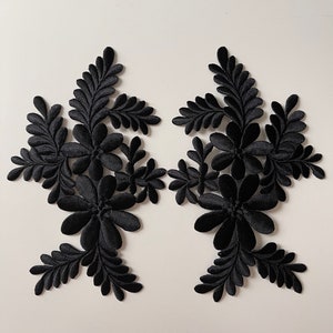 Peut inclure: Deux appliques florales en velours noir avec un design 3D. Les appliques sont en tissu et présentent un design délicat et complexe.