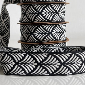 Peut inclure: Un rouleau de ruban noir et blanc avec un motif géométrique. Le ruban est tissé avec un motif en relief.