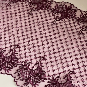May include: Burgundy lace trim with a scalloped edge and a repeating pattern of floral designs and stars.