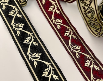 May include: Two decorative trim ribbons with a floral pattern. One ribbon is black with cream and gold accents, the other is burgundy with cream and gold accents.