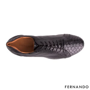 以下が含まれることがあります： ヘビ柄のブラックレザーレースアップシューズ